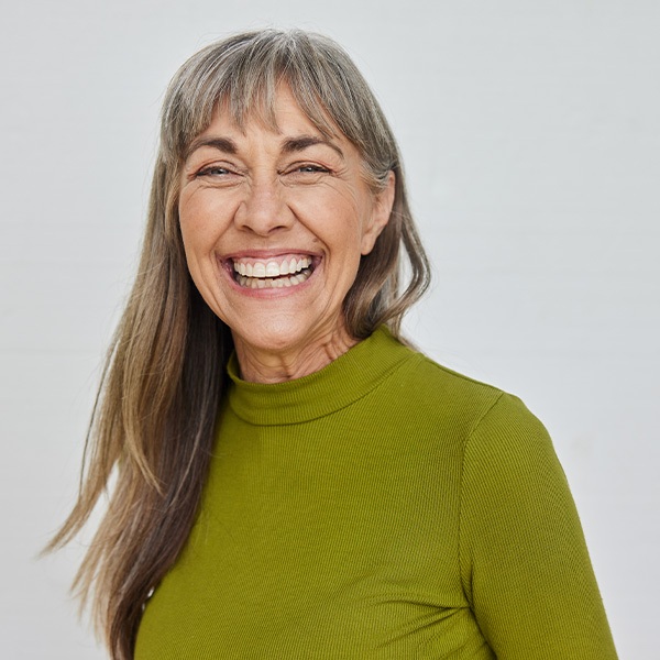 A headshot of a woman smiling big and bright, directly at the camera
